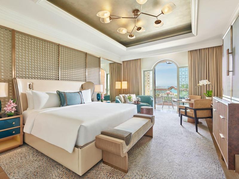 Elegantes Hotelzimmer mit Doppelbett, Sitzbereich und weitem Blick durch Panorama-Fenster.