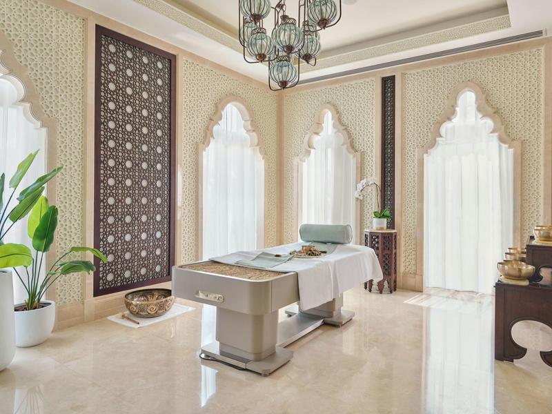 Eleganter Spa-Raum mit zwei Behandlungsliegen, großen Fenstern und luxuriöser Dekoration.