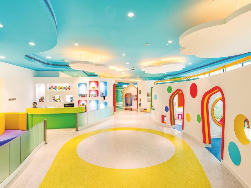 Bunte und helle Kindertagesstätte mit Rundbögen, Sitznischen und viel Spielraum.