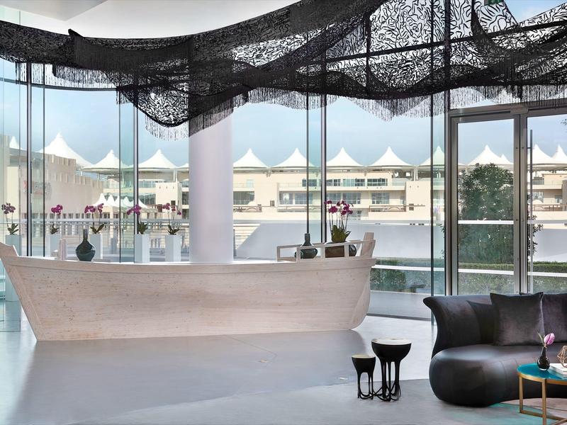 Helle Wohnung mit großen Fenstern, Bootssofa, schwarzem Netz über Kopf und modernem Mobiliar.