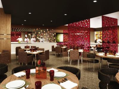 Modernes Restaurant mit dunklen Möbeln, roten Dekoelementen und offener Küche im Hintergrund.