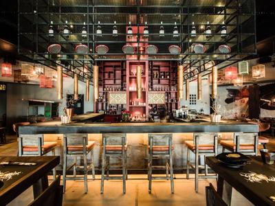 Moderner Hotelbar-Innenraum mit beleuchtetem Tresen und Barhockern.