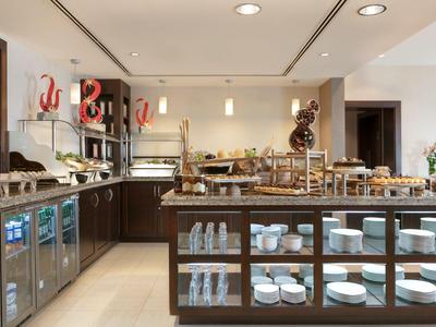 Buffetbereich mit verschiedenen Frühstücksoptionen und Gläsern in einem modernen Hotel.