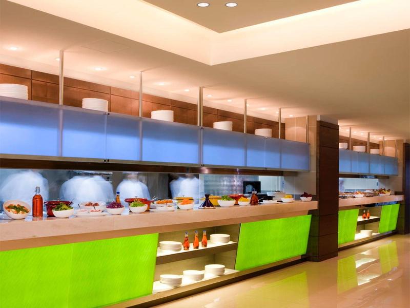 Moderner Restaurant-Buffet mit beleuchteten Theken und verschiedenen Speisen in Schalen und Tellern.