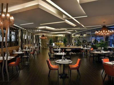 Modernes Restaurant mit stilvoller Beleuchtung und orangefarbenen Stühlen.