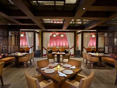 Elegantes Restaurant mit modernem Holzdekor und warmem Licht, Tische sind gedeckt.