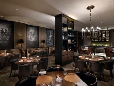 Elegantes Restaurantinterieur mit dunkler Einrichtung und stimmungsvoller Beleuchtung.