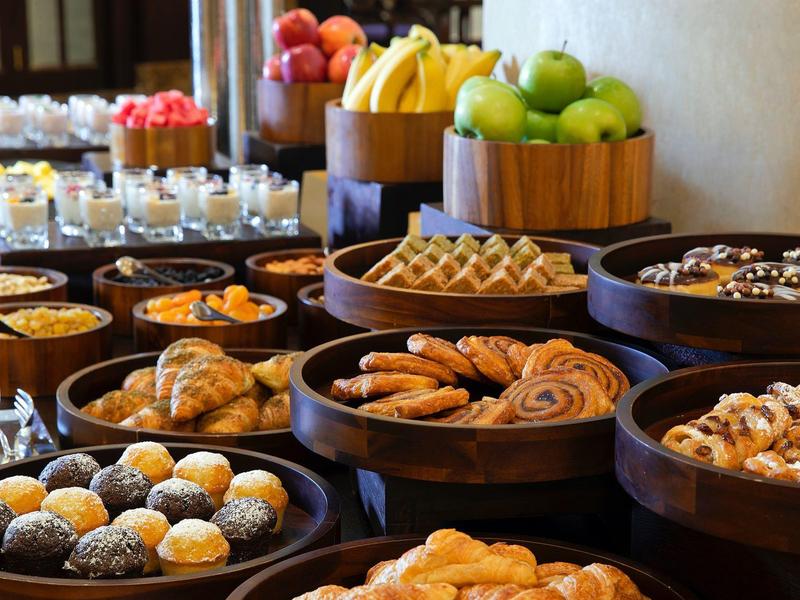 Buffet mit verschiedenen süßen Gebäckstücken, Früchten und kleinen Gläsern mit Desserts.