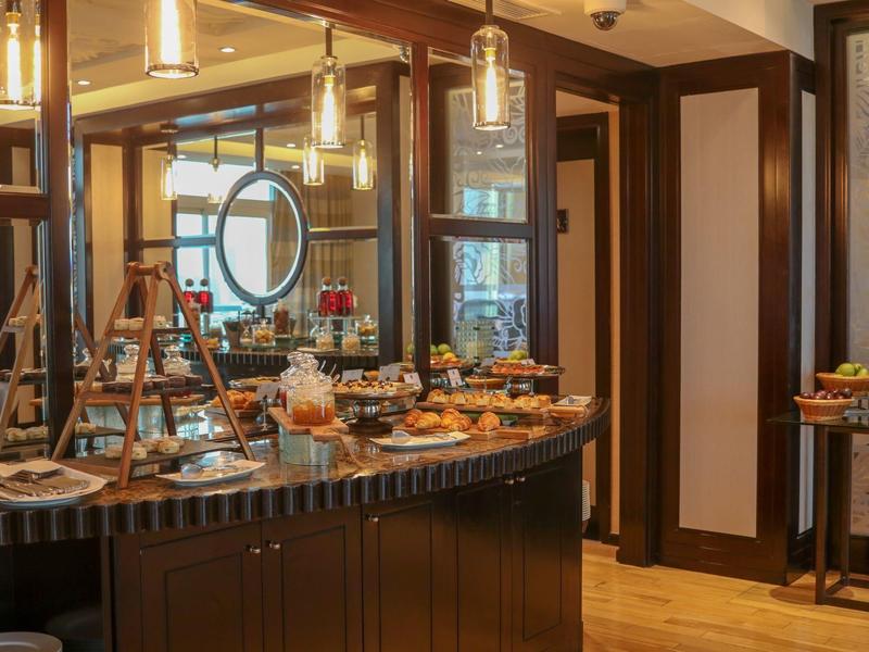 Gemütliches Buffet mit vielfältigen Backwaren, warmem Licht und moderner Holzeinrichtung.