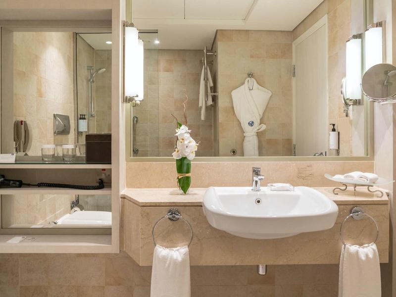 Moderne Badezimmer mit Waschbecken, Spiegel und Badewanne in neutralen Tönen