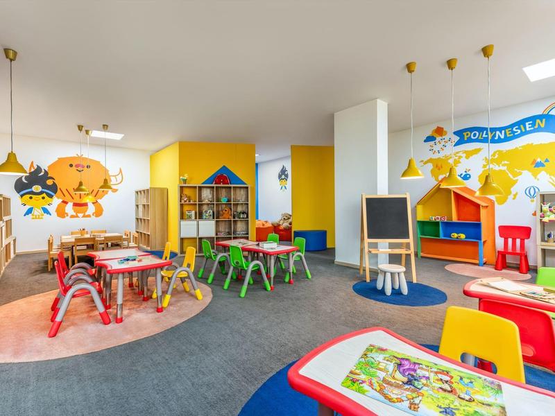 Bunten Kinderspielraum mit Tischen, Stühlen und Wanddekorationen in einem Hotel