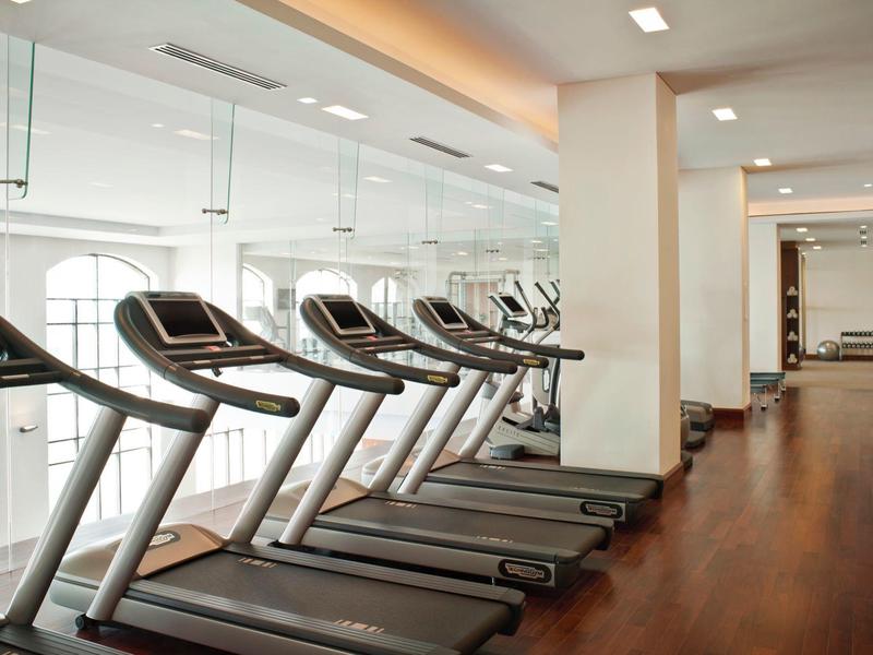 Moderne Fitnessraum mit mehreren Laufbändern und Holzboden im Hotel.