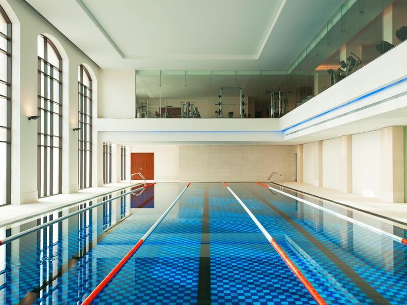 Hell beleuchtetes Hallenbad mit Bahnen, großen Fenstern und moderner Ausstattung.