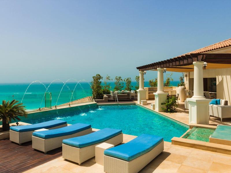 Moderner Pool mit Liegen und Blick auf das Meer in einem Luxushotel.