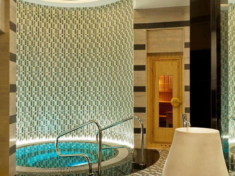 Luxuriöser Whirlpoolbereich mit elegantem Fliesenmuster und gedämpfter Beleuchtung.