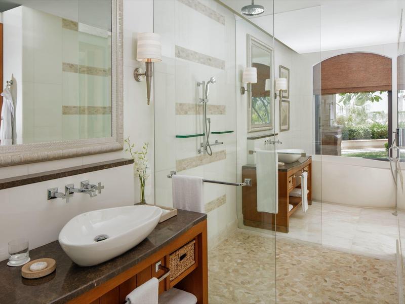 Moderne Badezimmereinrichtung mit Waschbecken, großer Spiegel und Duschbereich in hellem Design.