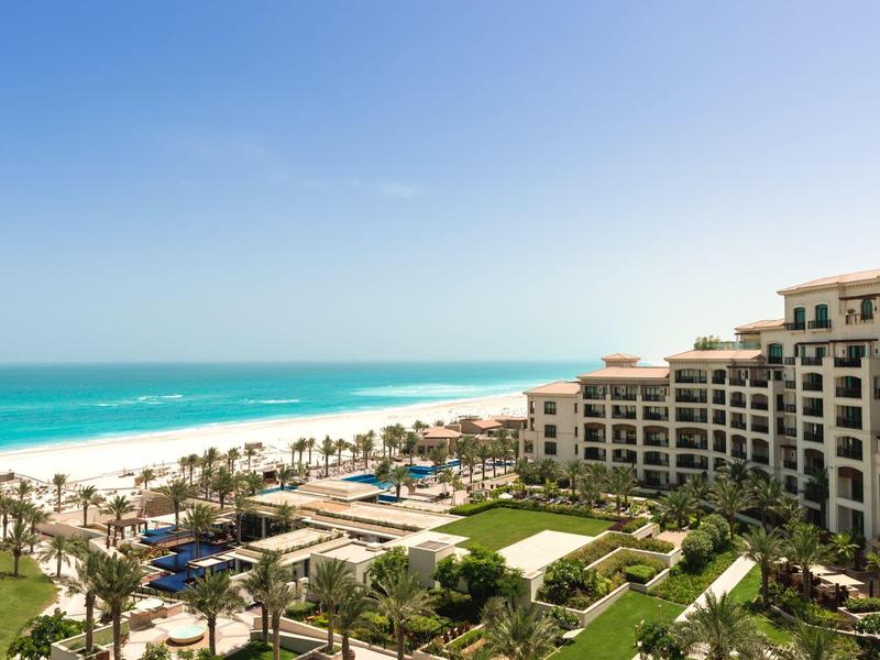 Luxuriöses Strandhotel mit Pool, Palmen und direktem Zugang zu weißem Sandstrand.