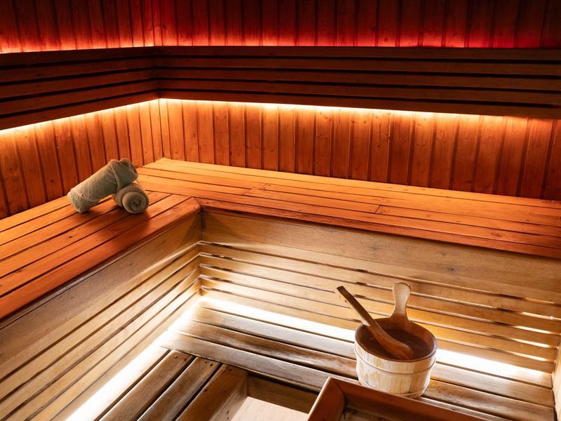 Gemütliche Sauna mit hellen Holzplanken und indirekter Beleuchtung