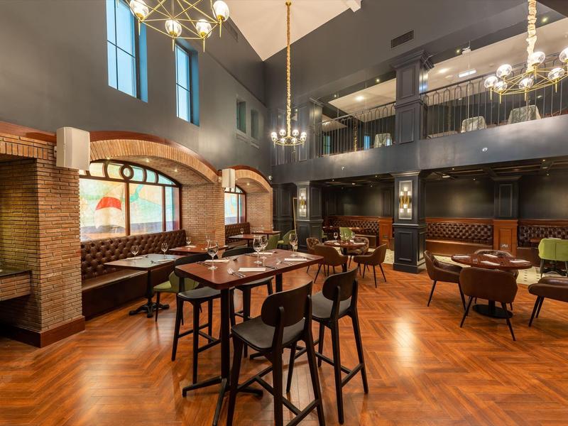 Moderner Hotel-Loungebereich mit hohen Decken, Holzböden und gemütlichen Sitzbereichen.