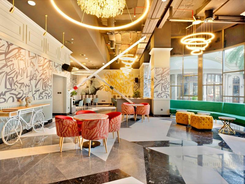 Modern eingerichteter Hotel-Lobbybereich mit stilvollen Sitzgelegenheiten und Kronleuchtern.