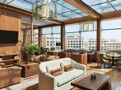 Helles Hotel-Lounge mit großen Glasfenstern, bequemen Sofas und Stadtblick.