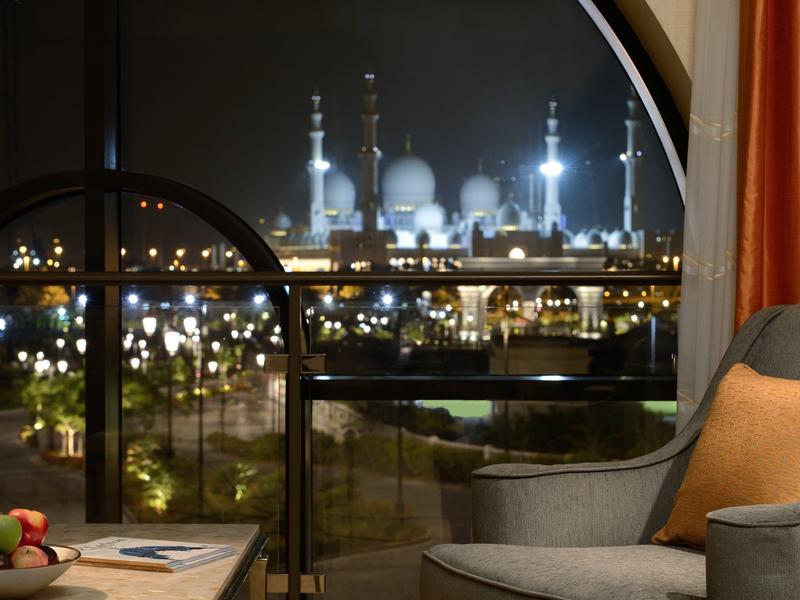 Vista notturna di una moschea illuminata attraverso una finestra rotonda da una camera d'albergo.