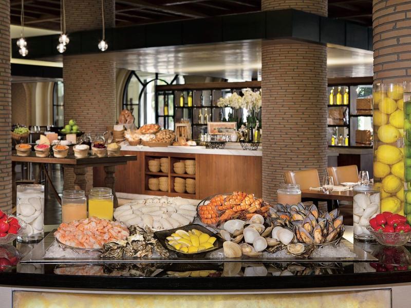 Buffet con vari frutti di mare, prodotti da forno e bevande in un ristorante elegante.