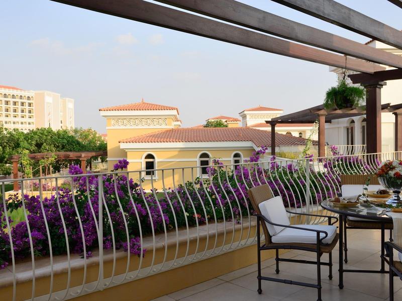 Balcone con mobili e vista su edifici e fiori sotto il sole
