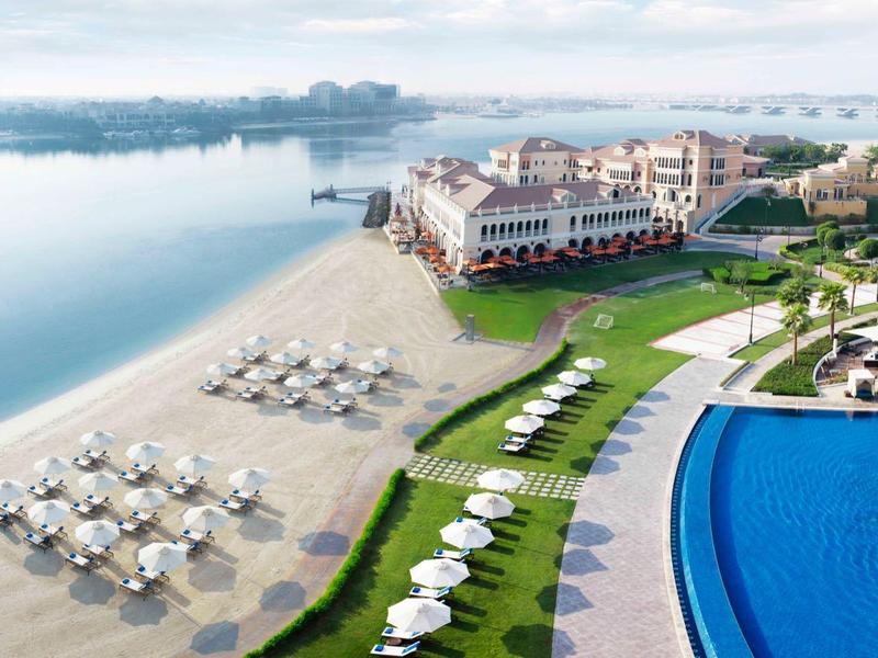 Resort di lusso con piscina, lettini e vista sul mare sotto un cielo sereno.