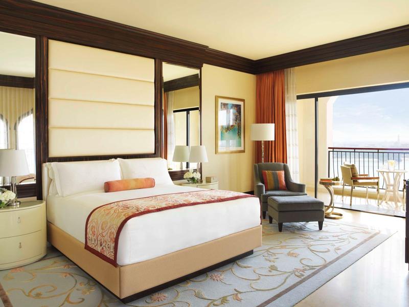 Camera d'hotel luminosa con letto grande e balcone con vista mare.