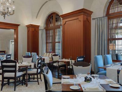 Sala da pranzo elegante con mobili in legno e grandi finestre in un hotel