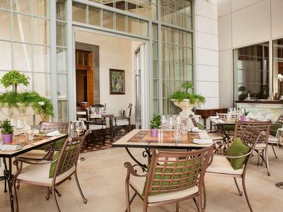 Ristorante moderno con sedie in metallo e piante decorative in un ambiente luminoso