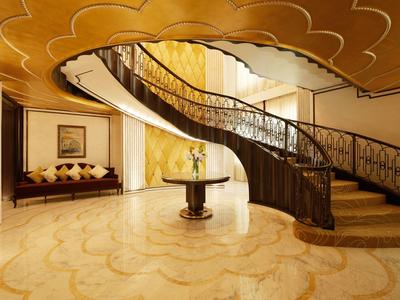 Großzügiger Eingangsbereich mit geschwungener Treppe, marmorboden und goldenen Deckenakzenten.