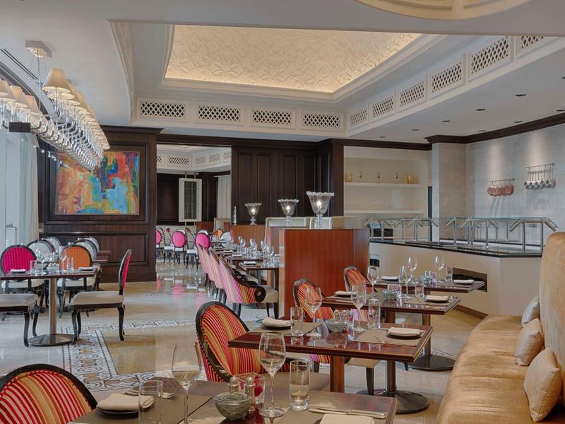 Restaurante elegante con mesas preparadas y ambiente acogedor en tonos cálidos.