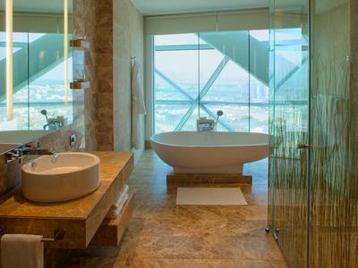 Baño moderno con bañera independiente y grandes ventanas con vistas.