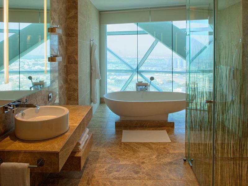 Baño moderno con bañera independiente y grandes ventanas con vistas.