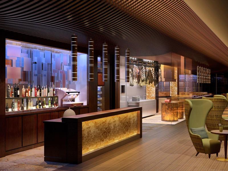 Moderne hotelbar met elegant verlichte balie en zitplaatsen.