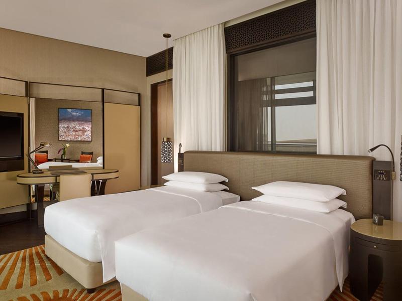 Modern hotelkamer met twee eenpersoonsbedden, bureau, stoel en gordijnen