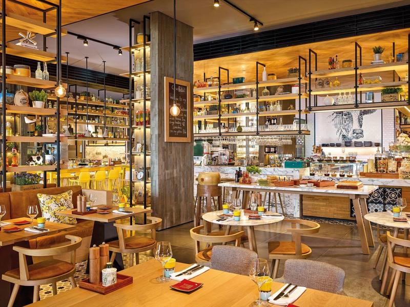 Modern, gezellig restaurantinterieur met houten meubels en buffetgedeelte.