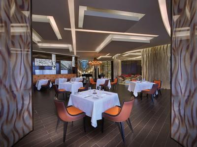 Nowoczesny pokój hotelowy z dużym łóżkiem, wygodną sofą i panoramicznymi oknami z widokiem na morze.