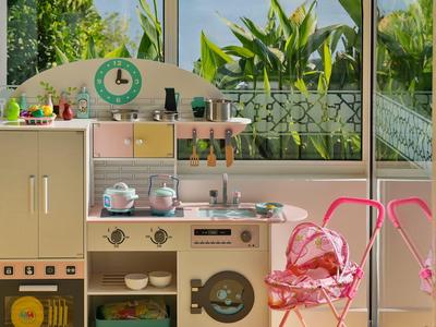 Acogedora esquina de cocina con electrodomésticos retro y sillas rosas junto a grandes ventanas con vista al jardín.