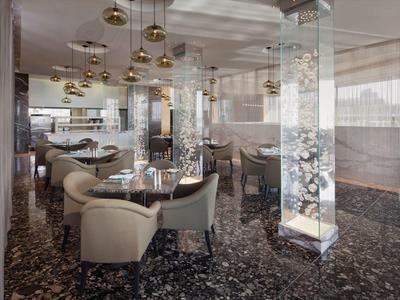 Área elegante de lounge en hotel con sillones modernos y columnas iluminadas artísticas.