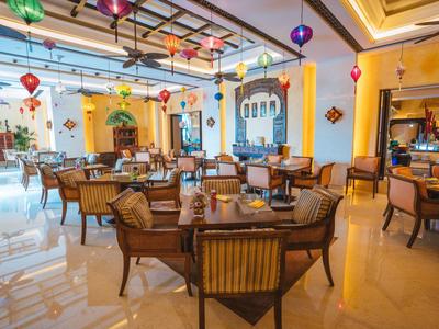 Elegancka sala jadalna w hotelu z udekorowanymi stołami i kolorowymi lampionami pod sufitem.