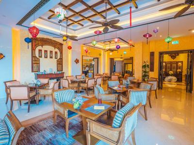 Restaurante luminoso y acogedor con muebles de madera y decoraciones coloridas en el techo.