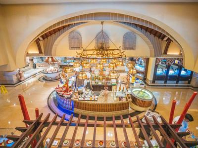 Vista de un lujoso restaurante interior con barra redonda y gran iluminación de araña.