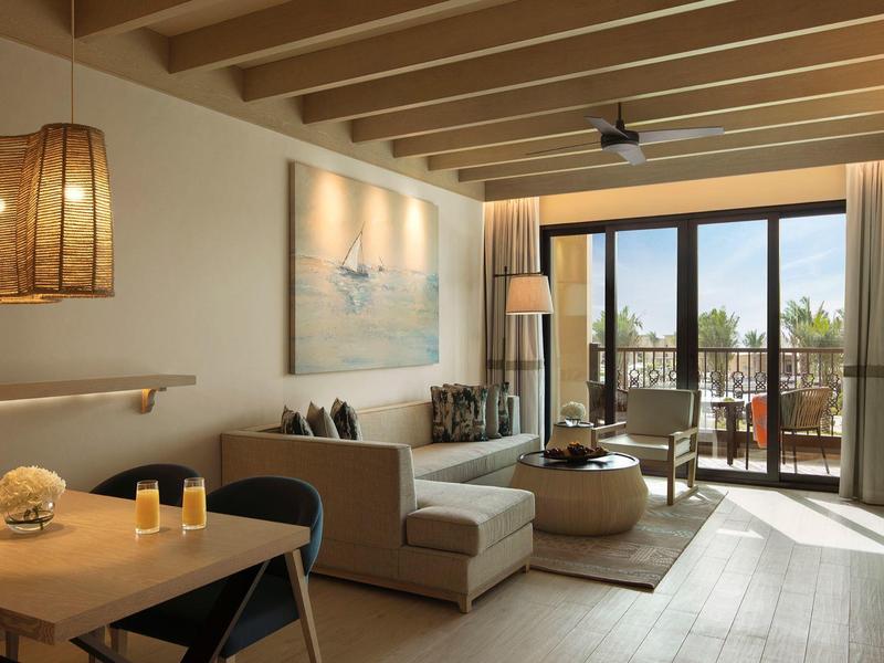 Cozy living room with sofa, fireplace, dining table, and balcony access with view.