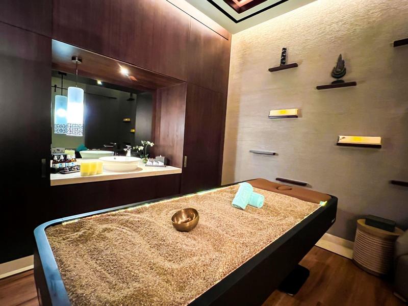 Warm treatment room with sand massage bed and calm atmosphere in hotel spa.