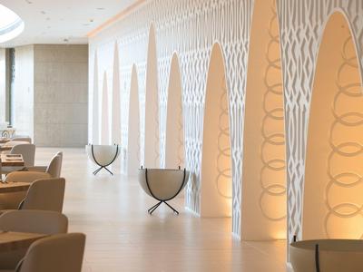 Espace salon d'hôtel lumineux avec fauteuils modernes et niches murales décoratives éclairées