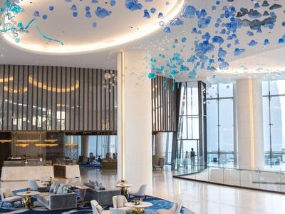 Elegantes Restaurant mit weißen Tischen, blauen Stühlen und großen Fenstern mit Meeresblick.