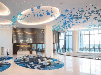 Elegantní hotelová lobby s moderním zařízením a velkými okny s výhledem na moře